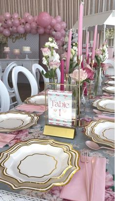 the table is set with pink and gold plates