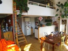 a kitchen and living room with stairs leading up to the second floor, in an apartment