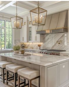 a kitchen with white cabinets and marble counter tops, an island with four stools