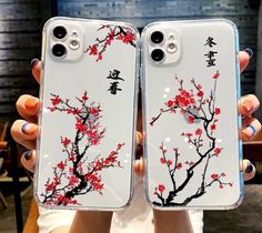 two people holding up their iphone cases with red flowers on them and chinese characters in the background