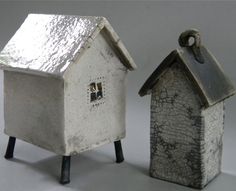 two small ceramic houses sitting next to each other