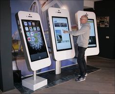 a man standing next to two large cell phones