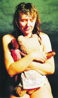 a woman holding a teddy bear in her arms