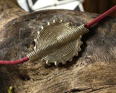 a piece of wood that has been carved into a tree stump with a red string attached to it