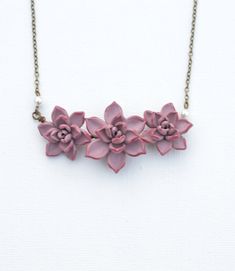 "Featuring Trio Pale Mauve Succulent Centered Necklace, Pale pink Purple Succulent Necklace, Succulent wedding Jewelry, Succulent Jewelry All Succulents Jewelry available at below link: https://www.etsy.com/shop/Diaszabo?ref=listing-shop2-all-items-count&section_id=20503443 Material and size : Hand wired Trio Succulents. Size approximately 25-26mm and 30mm across. Cream Swarovski pearls. Antiqued brass chain ( pictured). Available in silver plated, gold plated. The entire length available in Pink Necklace With Flower Charm For Wedding, Pink Wedding Necklace With Flower Charm, Pink Flower Charm Necklace For Wedding, Adjustable Pink Flower Necklace For Wedding, Succulent Necklace, Succulent Jewelry, Purple Succulents, Succulent Wedding, Bib Necklaces