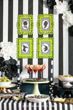 a table topped with desserts and drinks on top of a black and white striped table cloth