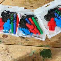 three plastic bags filled with different colored pieces of electrical wire sitting on top of a wooden table