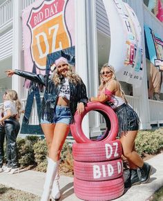 two women standing next to a giant tire