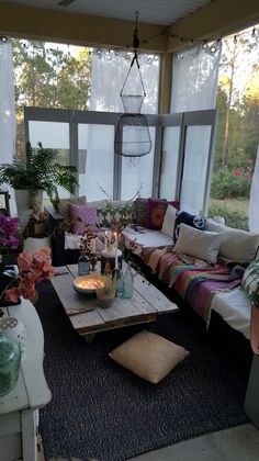 a living room filled with lots of furniture and flowers on top of the couches