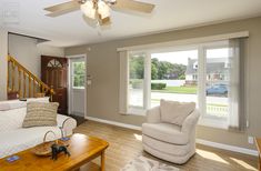 a living room with white furniture and wooden floors