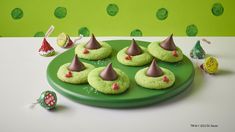 a green plate topped with cookies covered in frosting