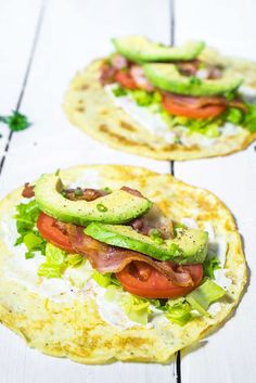 two tortillas with avocado, tomato and lettuce on them