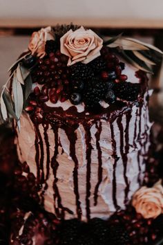 a close up of a cake on a plate with berries and flowers around it,