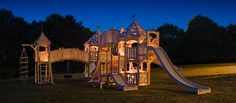 a children's wooden play set lit up at night with lights on the slide