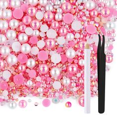 pink and white beads with black handles are next to a pair of eyeliner brushes