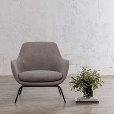 a grey chair next to a potted plant