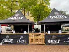 two black and white tents with logos on them