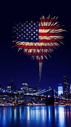 fireworks in the shape of an american flag are lit up over a city at night