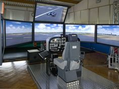 a control room with multiple monitors and two planes on the runway in front of them