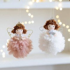 two little angel ornaments hanging from strings