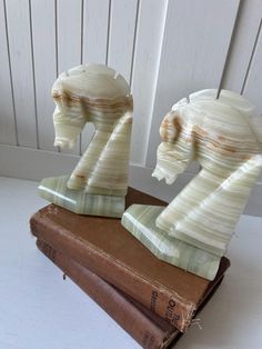 two ceramic horse heads sitting on top of a book