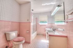 a bathroom with pink and white walls and tile flooring is pictured in this image