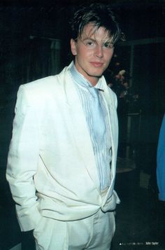 a young man in a white suit and tie