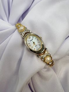 Elevate your style with this stunning Oldmoney Vivani wristwatch, featuring a radiant gold case and a beautiful mother of pearl dial pattern. This analog watch is powered by a precise quartz movement, ensuring reliable timekeeping for years to come. The watch is designed for women and features a diamond bezel type, adding an elegant touch to the overall look. New battery installed. Keeping time correctly. Hour minute and seconds hand for accurate time. Mother of pearl dial. Measurements in pictures. Thank you for looking. Preppy Chic, Analog Watch, Pearl Diamond, Gold Case, Women Wrist Watch, Bezel Diamond, Wrist Watches, Quartz Movement, Mother Of Pearl