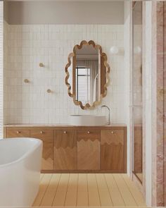 a bathroom with a sink, mirror and bathtub in it's center area