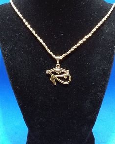 Gold 24 kt Eye of Horus Charm Necklace ☆  Wedjat Eye | Eye of Ra ☆  Eye of Horus Necklace | African Jewelry ☆  For Him or Her | Protection Amulet☆  Golden Eye of Horus measures 1.25 inches wide     by 1 inch high☆ Strung on a gold snap-on bale☆ An 18 inch long 2 mm wide gold rope chain     with lobster clasp is also included.☆ FREE Eco-Packaging in a Jewelry Gift Box & Gift Bag!☆ Ships same day as order to USA.☆ A FREE GIFT is included with every order!☆ FREE USA Shipping on orders of $35 or Gold Ankh Metal Jewelry, Gold Ankh Shaped Metal Jewelry, Gold Rope Chain Jewelry As A Gift, Gold Pendant Charm Necklace With Rope Chain, Handmade Gold Ankh Necklace, Handmade Ankh Gold Necklace, Gold Symbolic Metal Necklaces, Symbolic Gold Metal Necklace, Gold Plated Spiritual Charm Necklaces