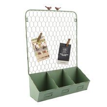 a green metal mail holder with three compartments and two birds on the top of it