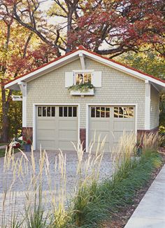 a garage with plants and flowers on the roof