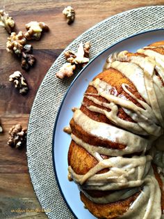 a cinnamon roll covered in icing sitting on top of a blue and white plate