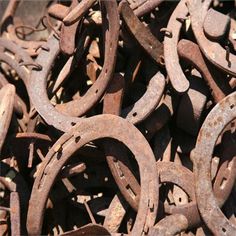 many rusty metal rings are piled together