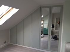 an attic bedroom with mirrored closet doors