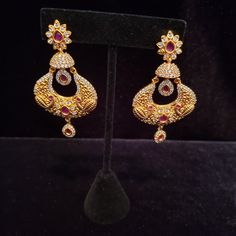 "These Jhumka Earrings set have an excellent finish and gives out an exquisite sense of style. If you are looking for an amazing Fashion Jewelry set for special occasions such as Anniversary, Engagement, Party, Wedding or for gifting , then your search ends here. Handmade Indian Temple Jewelry, best to wear it for traditional ceremonies or Indian wedding. This bridal jewelry has ethnic finish. It has Cubic Zircon stones with ruby and emeralds. It is a Bollywood style one gram jewelry. There are Jeweled Drop Earrings For Celebrations, Celebration Chandbali Jewelry With Cubic Zirconia, Celebratory Chandbali Cubic Zirconia Jewelry, Cubic Zirconia Chandbali Jewelry For Celebration, Traditional Jeweled Pearl Earrings For Party, Chandbali Hoop Earrings For Formal Occasions, Bollywood Jeweled Chandelier Earrings For Celebration, Bollywood Style Jeweled Chandelier Earrings For Celebration, Traditional Jeweled Pearl Earrings For Wedding