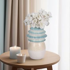 a vase with flowers and candles on a table