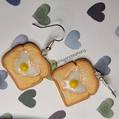 two slices of toast with an egg in the middle are hanging from hooks on a table