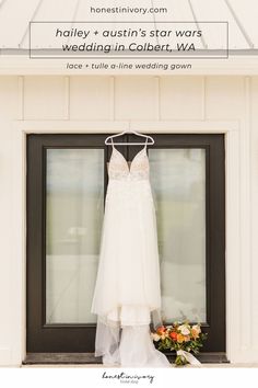 a wedding dress hanging in front of a window