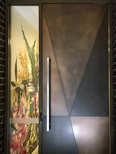 a door with an artistic painting on the wall next to it and a brick wall behind it