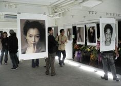 people are standing around looking at pictures on display