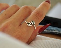 a woman's hand with a dog paw ring on it