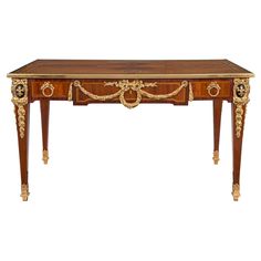 an antique wooden table with gold decorations on it