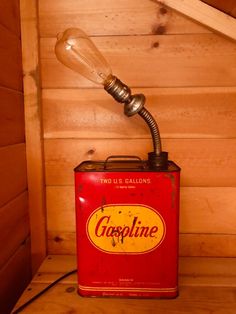 an old style lamp sitting on top of a red can with the word goppline underneath it