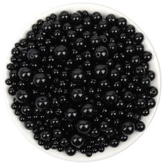 black beads in a white bowl on a white background