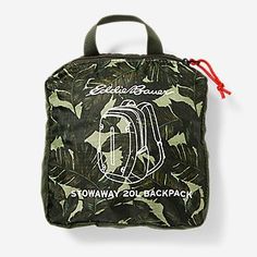 the back side of a green and black camouflage print bag with red string attached to it