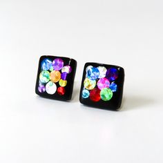 Fun and colorful black square studs with flashy glitter in reds, pinks, blues, yellows and other rainbow colors.  Hard resin finish brings out all the ranges of color with each change in direction.  Hypoallergenic titanium posts, excellent for sensitive ears.   Squares measure 10mm. // Info: * Titanium posts * 100% Nickel-free * Hypoallergenic for sensitive ears * Hand sculpted, ultra lightweight We always include a pair of spare silicone backings with each order! Other colors in this section of