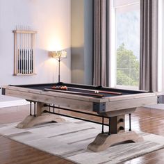 a pool table sitting on top of a hard wood floor next to a lamp and window