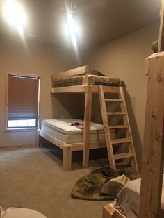 bunk beds are in the middle of a room with two ladders on each side