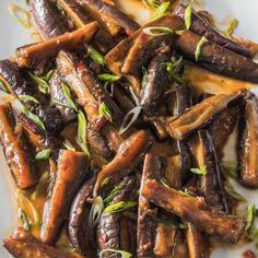 a white plate topped with cooked carrots covered in sauce